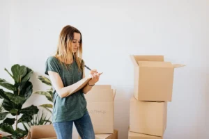 Person using a moving house checklist UK to organize boxes